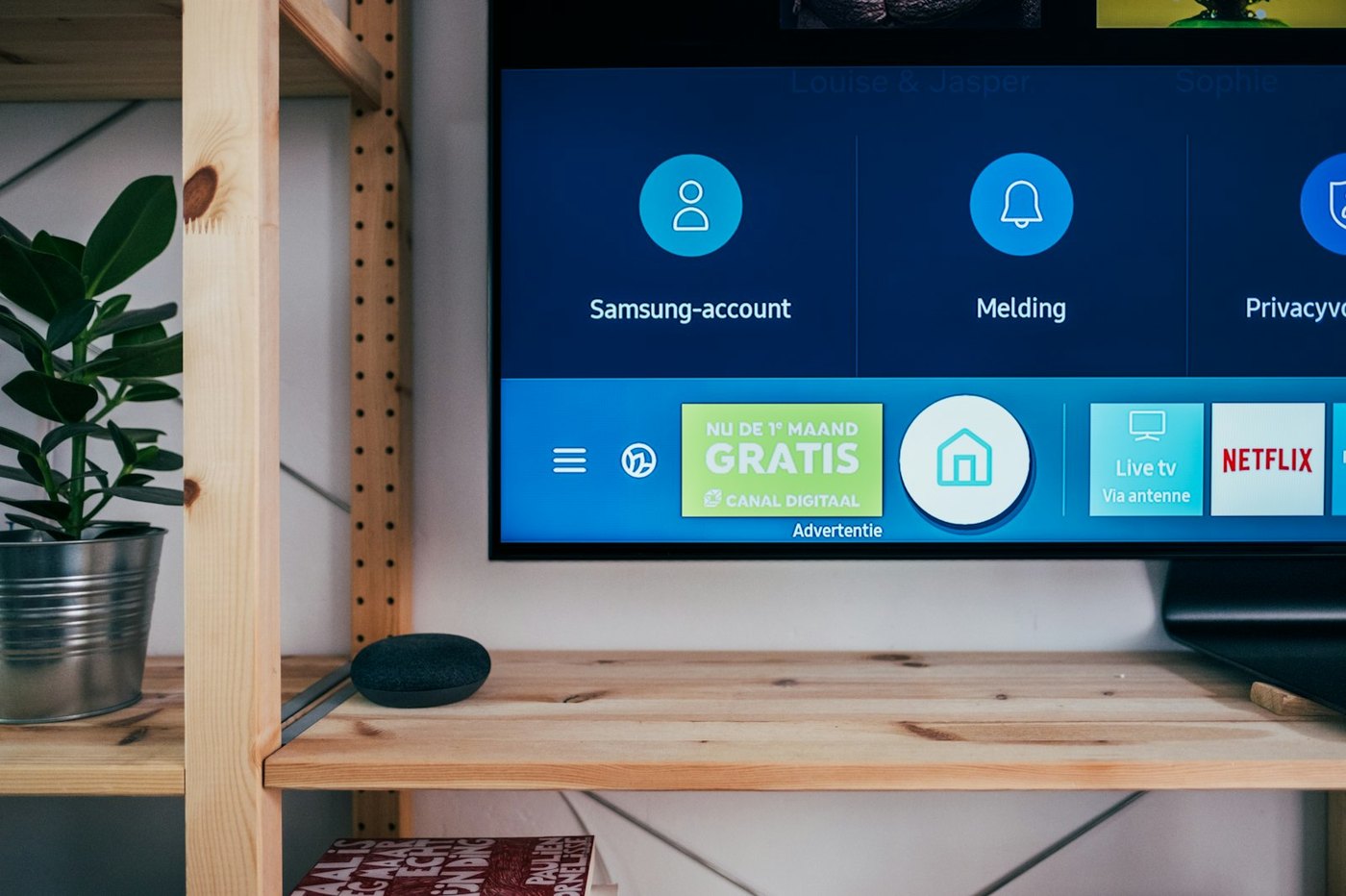 A living-room television on a wooden shelf